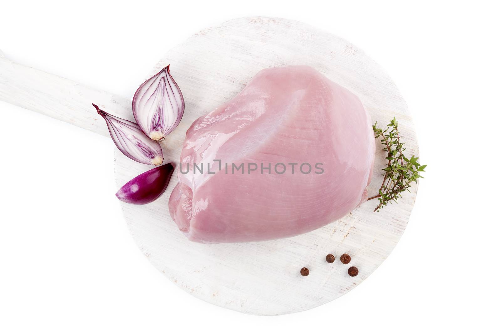 Fresh raw turkey meat on white wooden round chopping board isolated on white background. Culinary meat eating. 