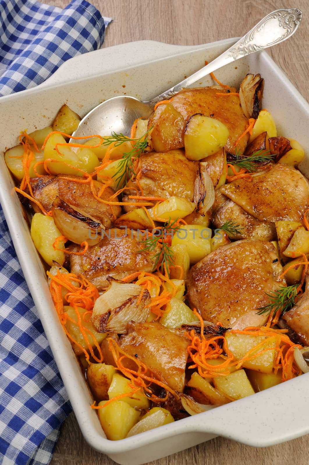 roast chicken with potatoes and vegetables in ceramic roasting pan