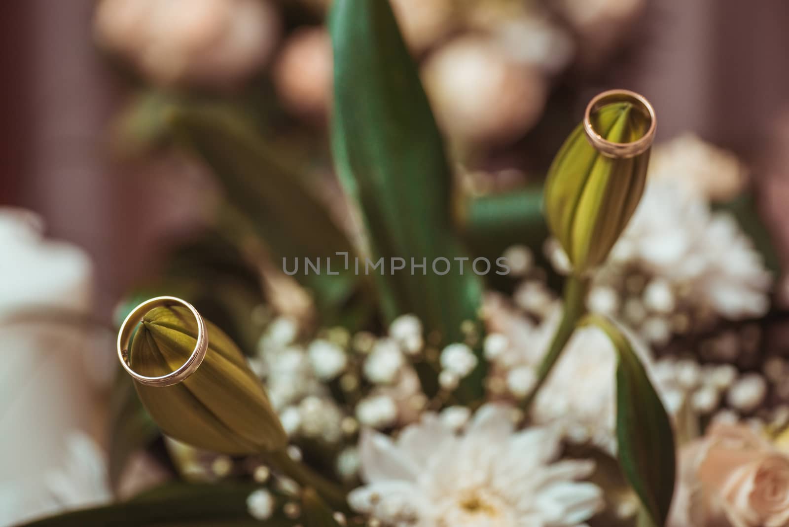 Wedding rings  laying on  bouquet. Macro shot by skrotov