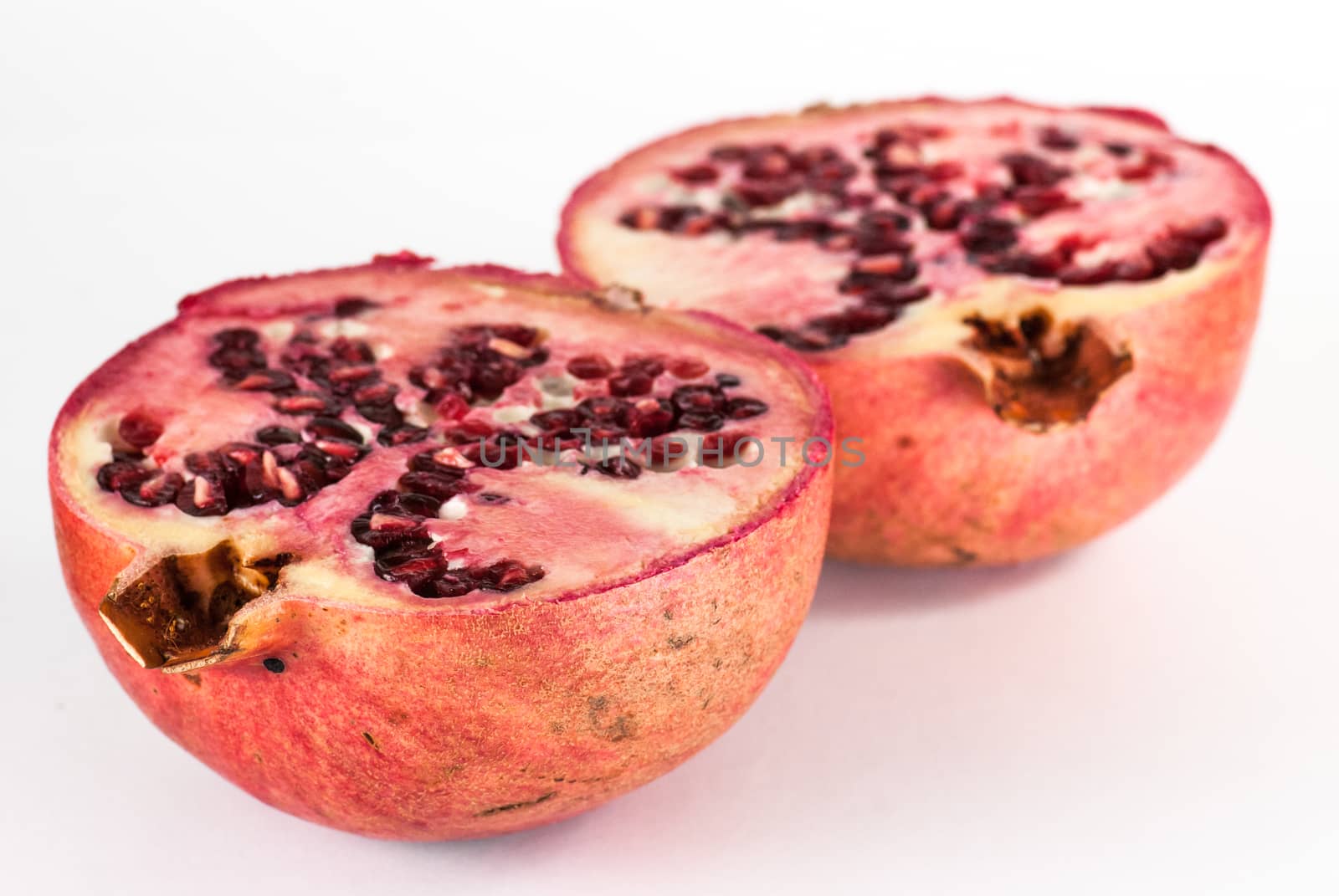 two halfs ripe pomegranate fruit isolated on white background cutout by skrotov