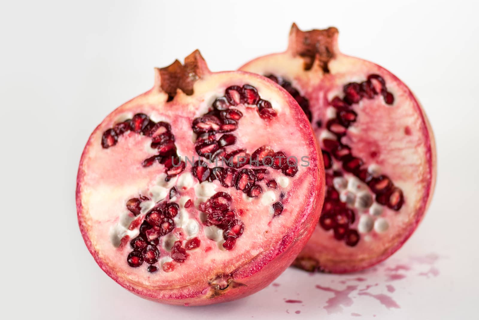 two halfs ripe pomegranate fruit isolated on white background cutout by skrotov