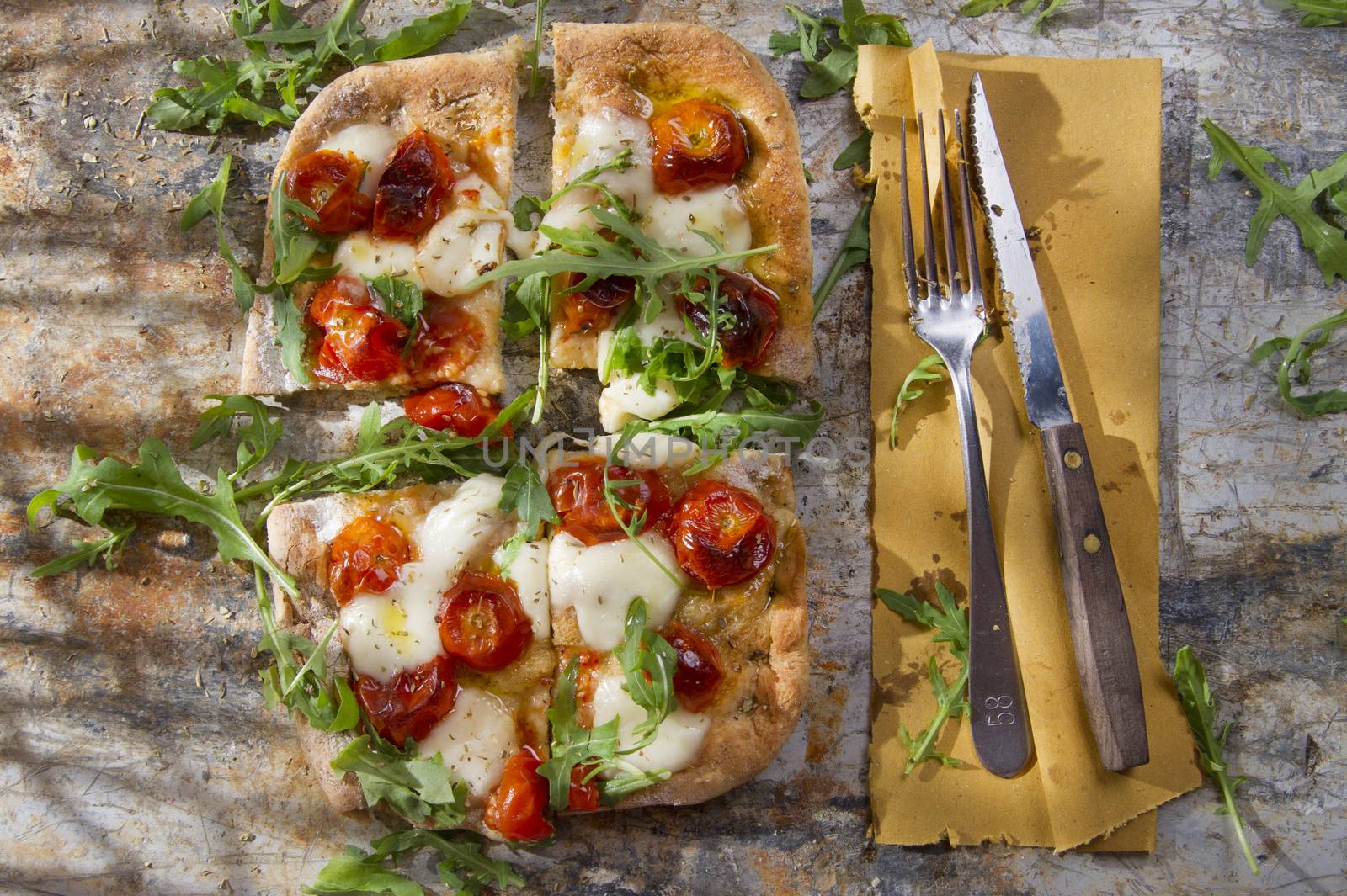 Tricolor pizza with tomato mozzarella and fresh arugula 