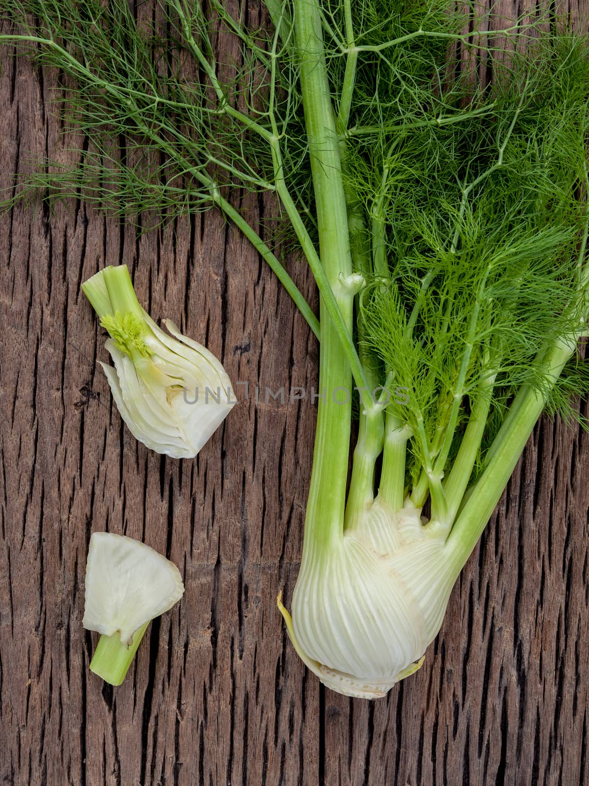 Fresh organic fennel bulbs for culinary purposes on wooden backg by kerdkanno
