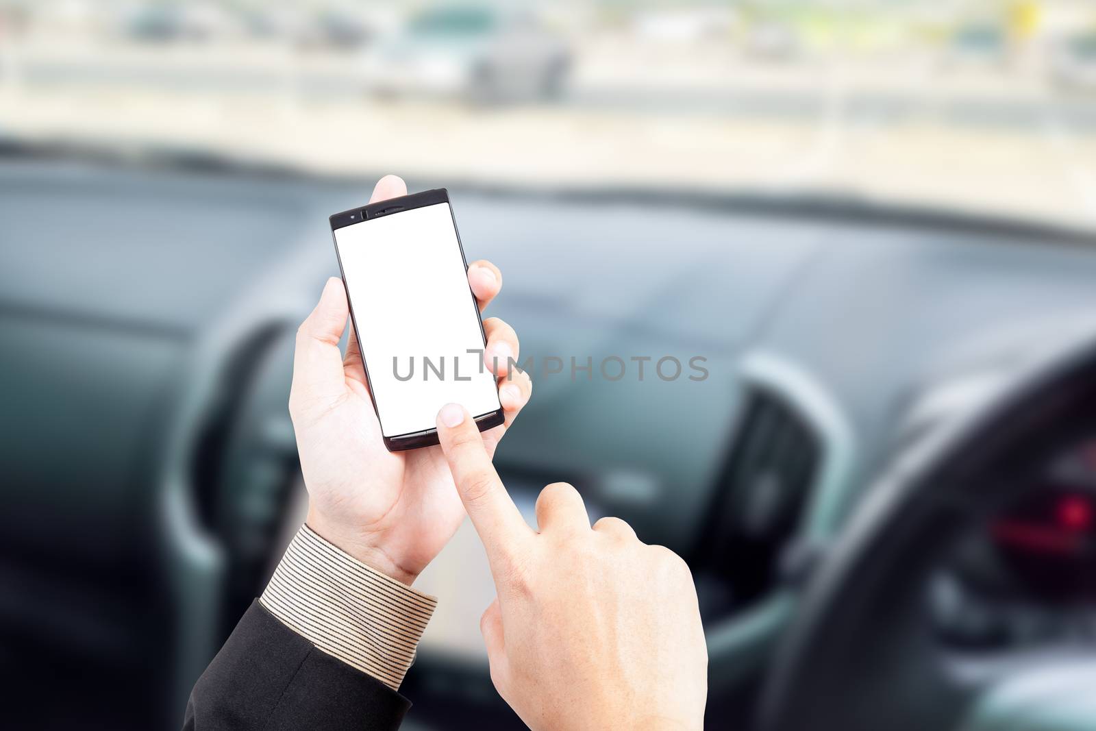 Hand holding smart phone text message in car blur background road safety concept