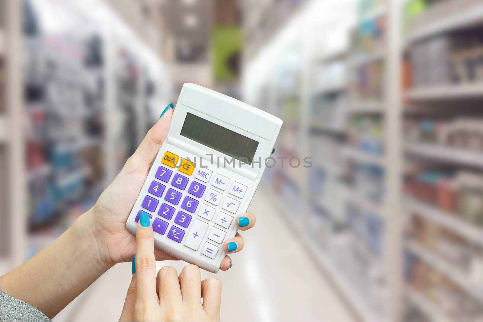hand holding calculator with blur background of shopping mall market, business financial or shopping concept