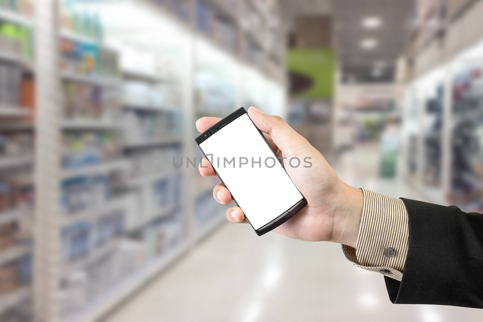 Hand holding smart phone with blur background of shopping mall m by FrameAngel