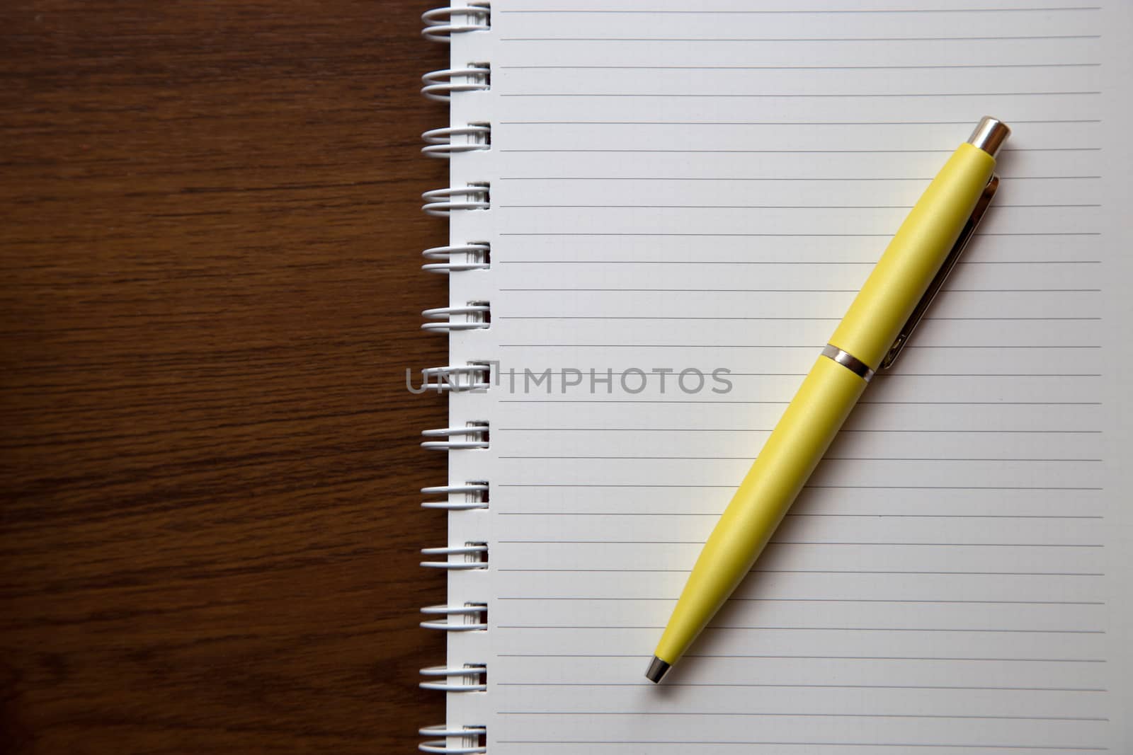 Notebook on wooden desk by liewluck