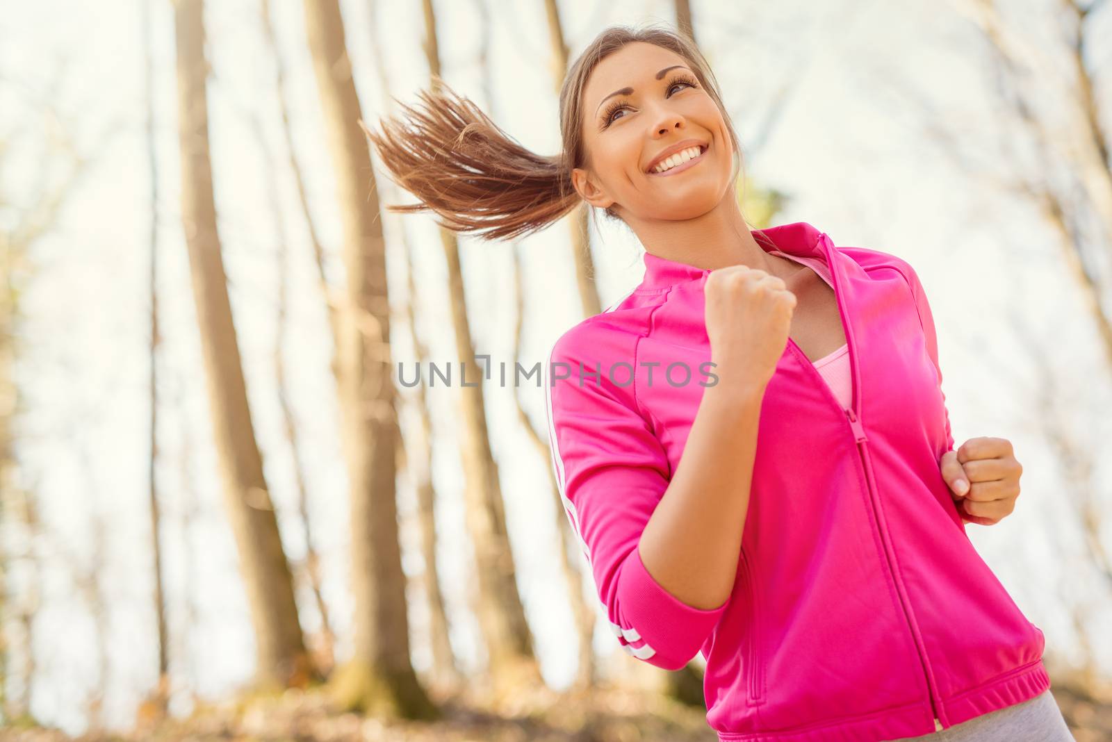 Happy young beautiful woman running in nature. 