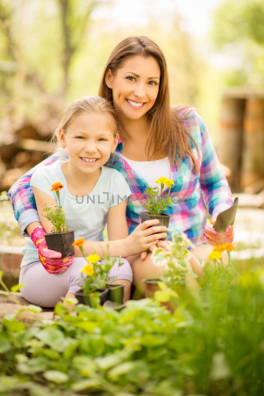 Beautiful mother and daughter planting flowers together.