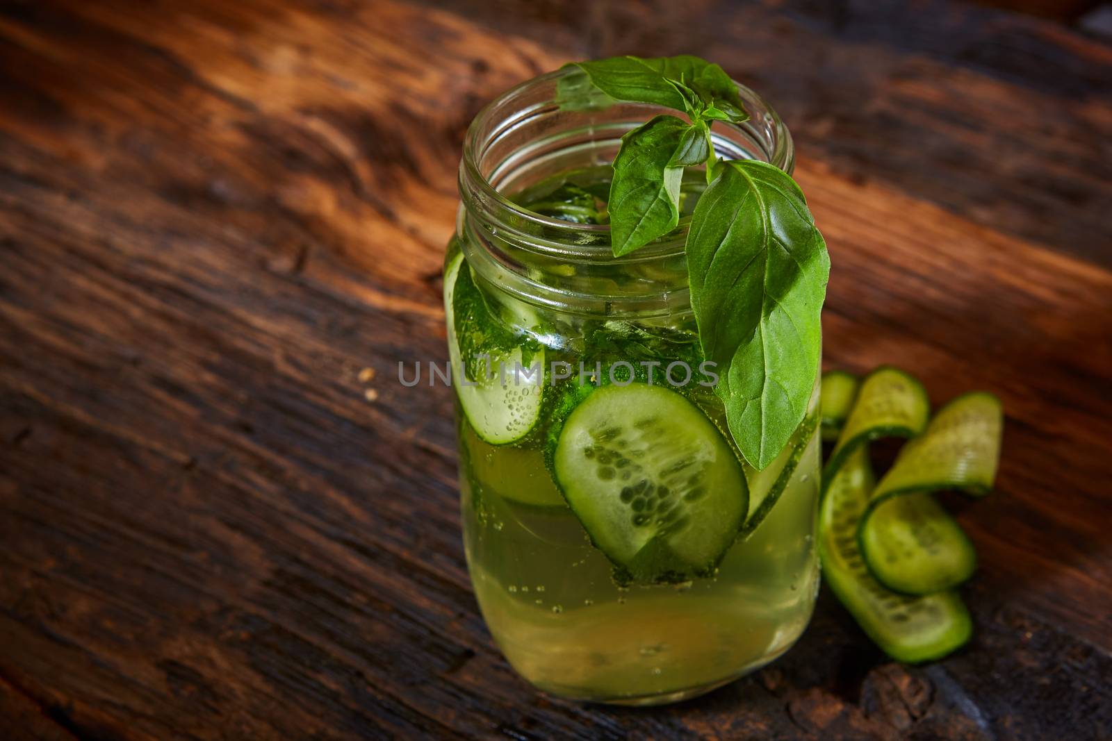 The Basil cucumber home-made lemonade on rustic background in mason jars 