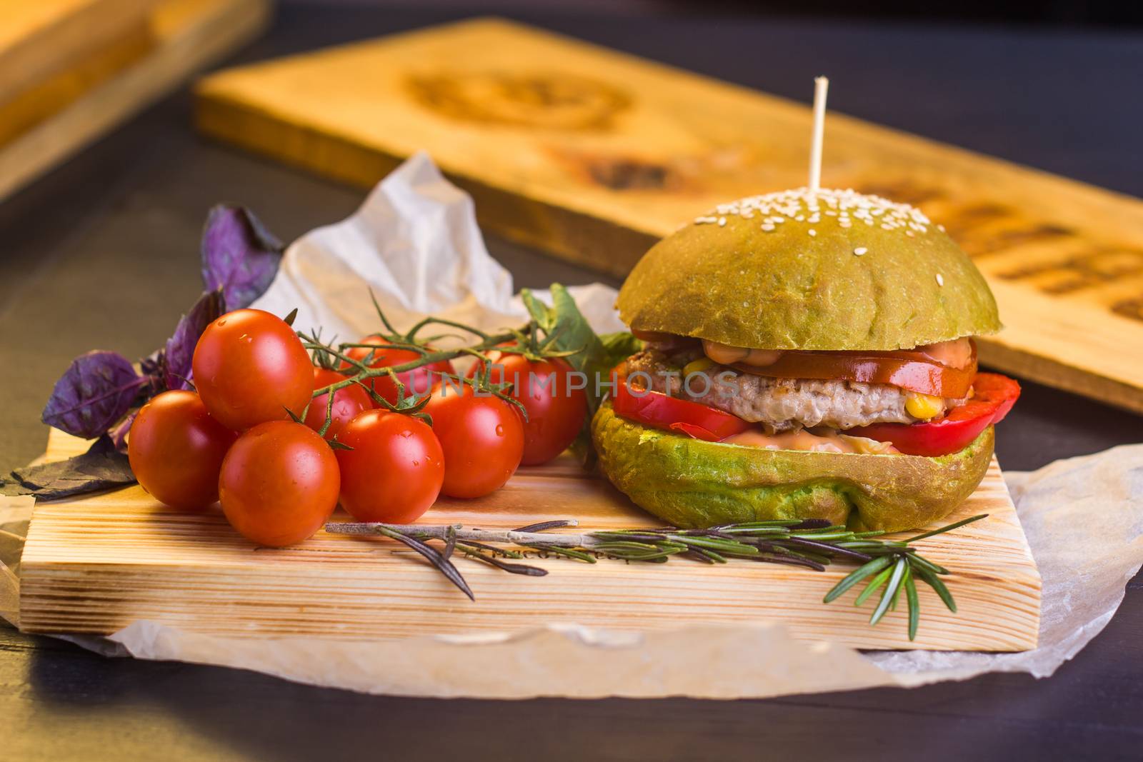 Concept: healthy food. Gourmet homemade burger with garnish and ingredients on the dark background.