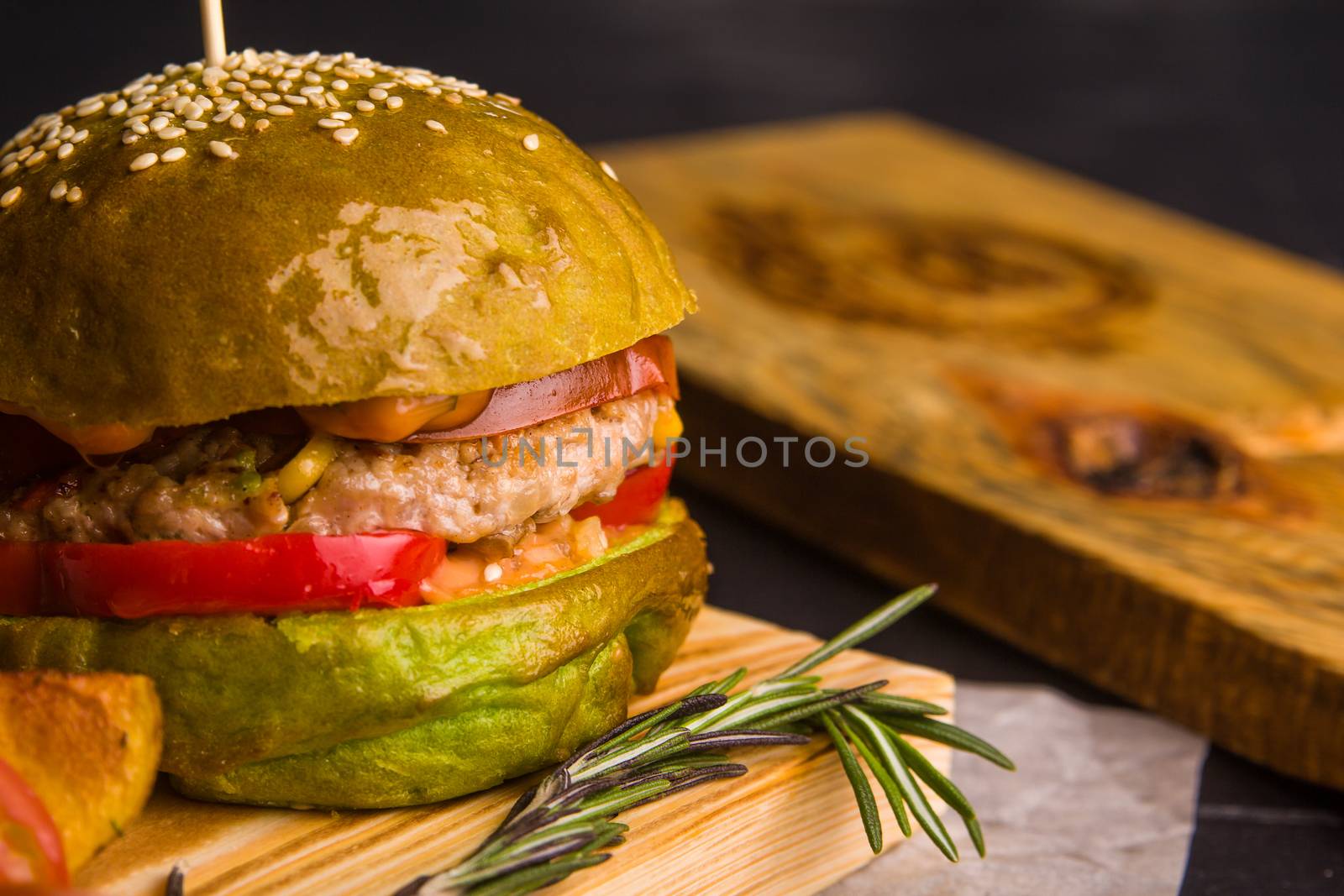 Concept: healthy food. Gourmet homemade burger with garnish and ingredients on the dark background.