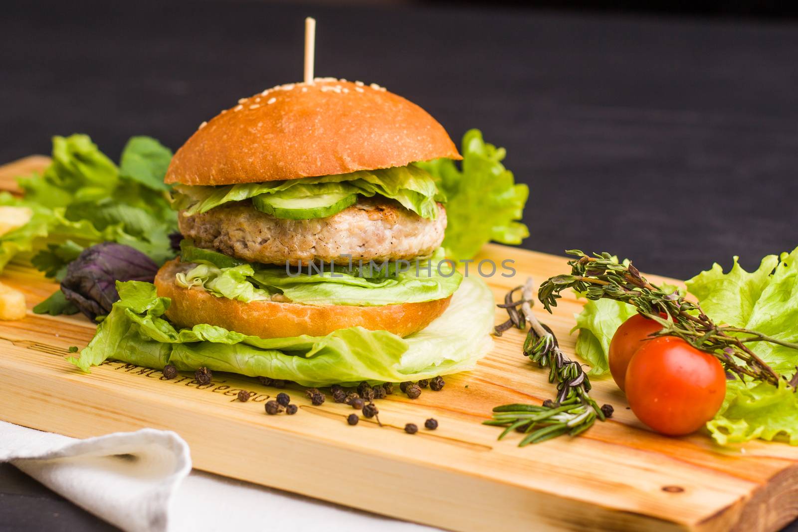 Concept: healthy food. Gourmet homemade burger with garnish and ingredients on the dark background.