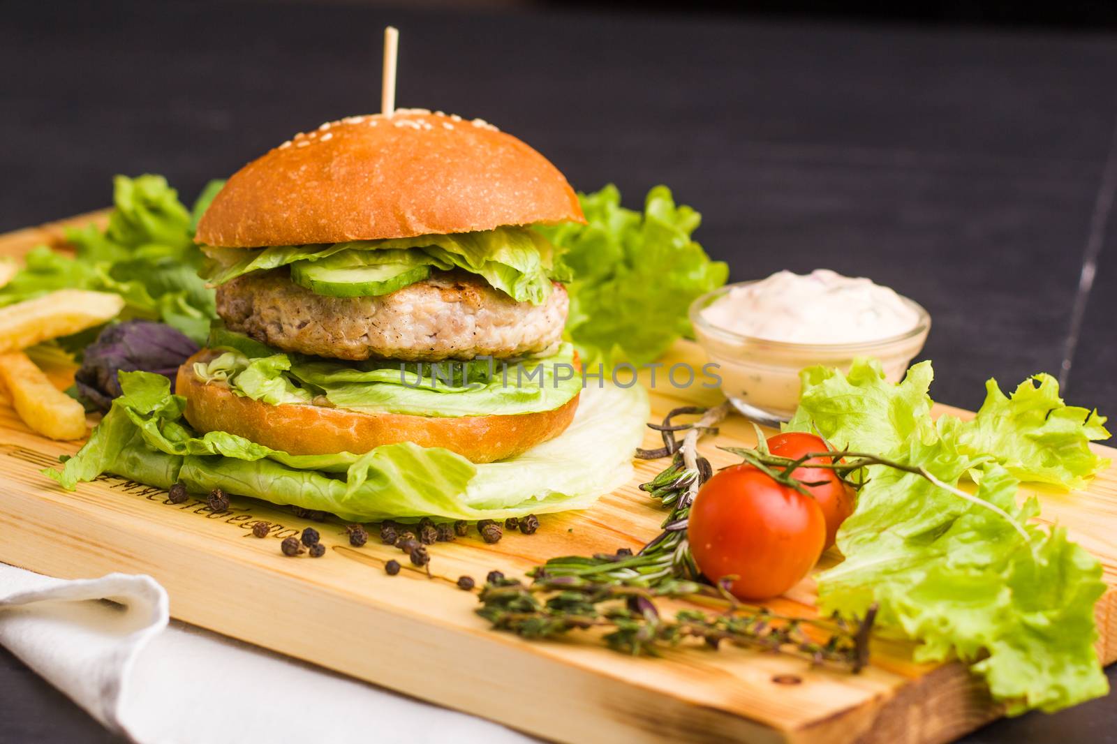 Concept: healthy food. Gourmet homemade burger with garnish and ingredients on the dark background.