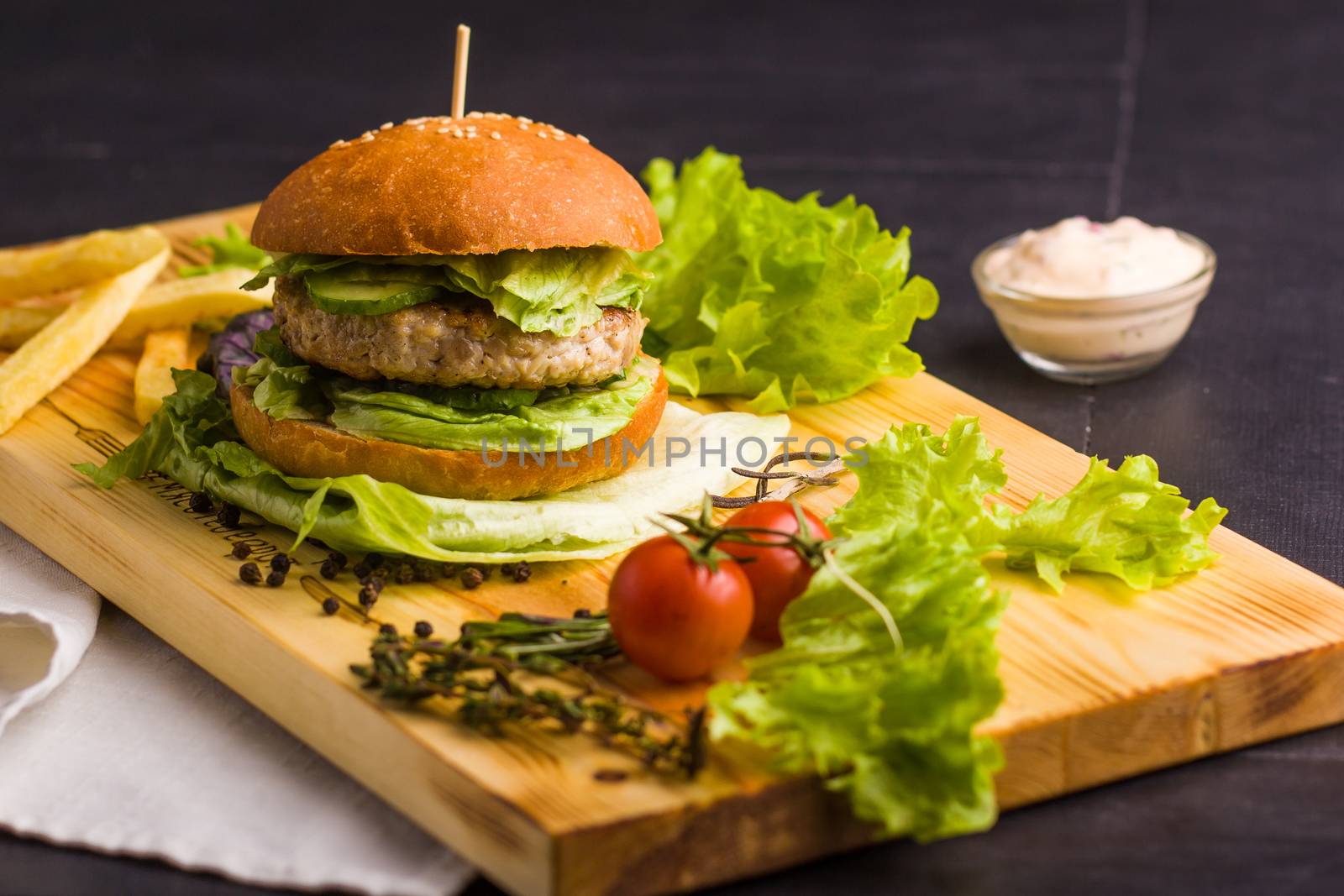 Concept: healthy food. Gourmet homemade burger with garnish and ingredients on the dark background.
