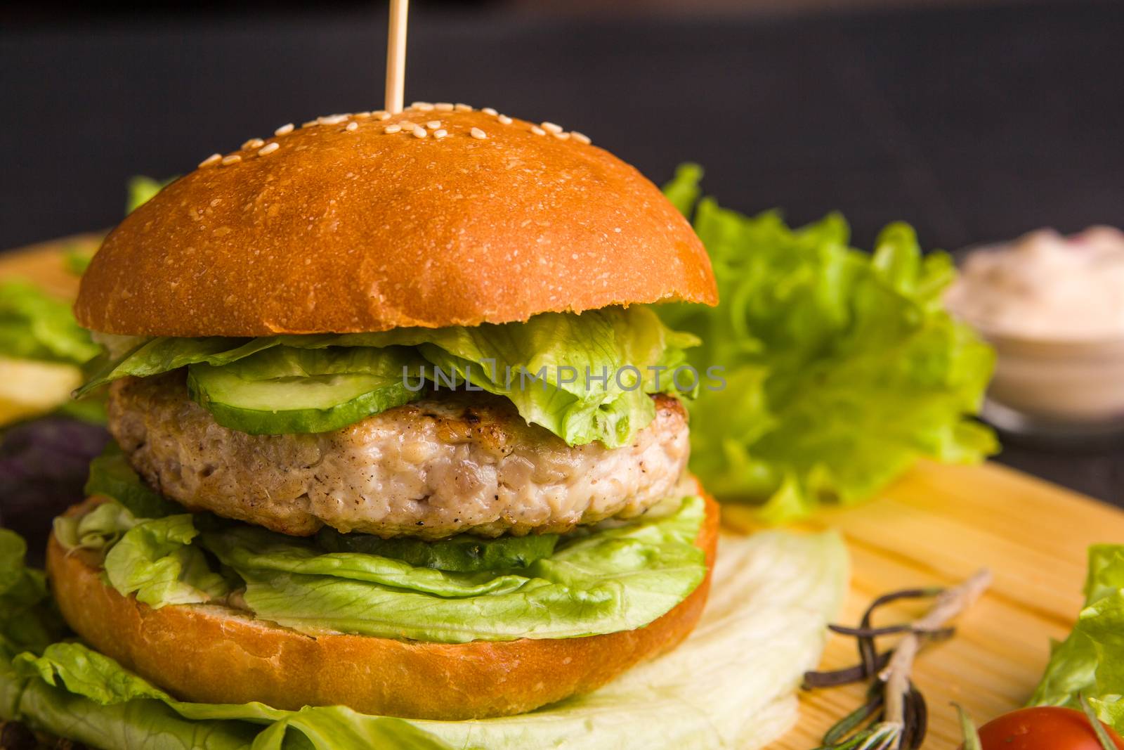 Concept: healthy food. Gourmet homemade burger with garnish and ingredients on the dark background.