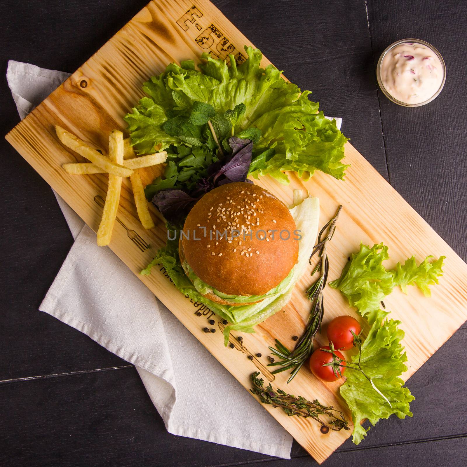 Concept: healthy food. Gourmet homemade burger with garnish and ingredients on the dark background.