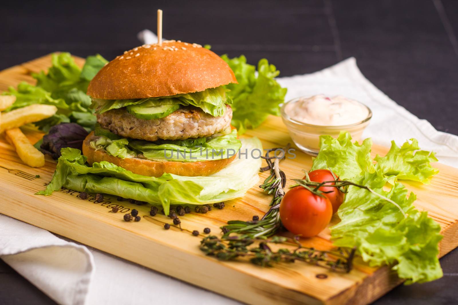 Concept: healthy food. Gourmet homemade burger with garnish and ingredients on the dark background.