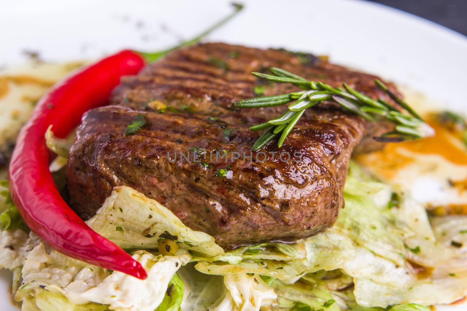 Grilled veal steak with vegetables on a plate by mrakor