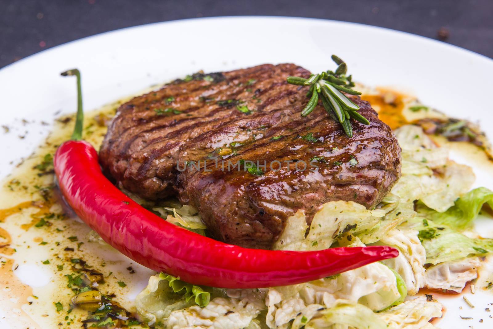 Concept: healthy food. Homemade grilled veal steak and vegetables on a plate with ingredients and cutlery around