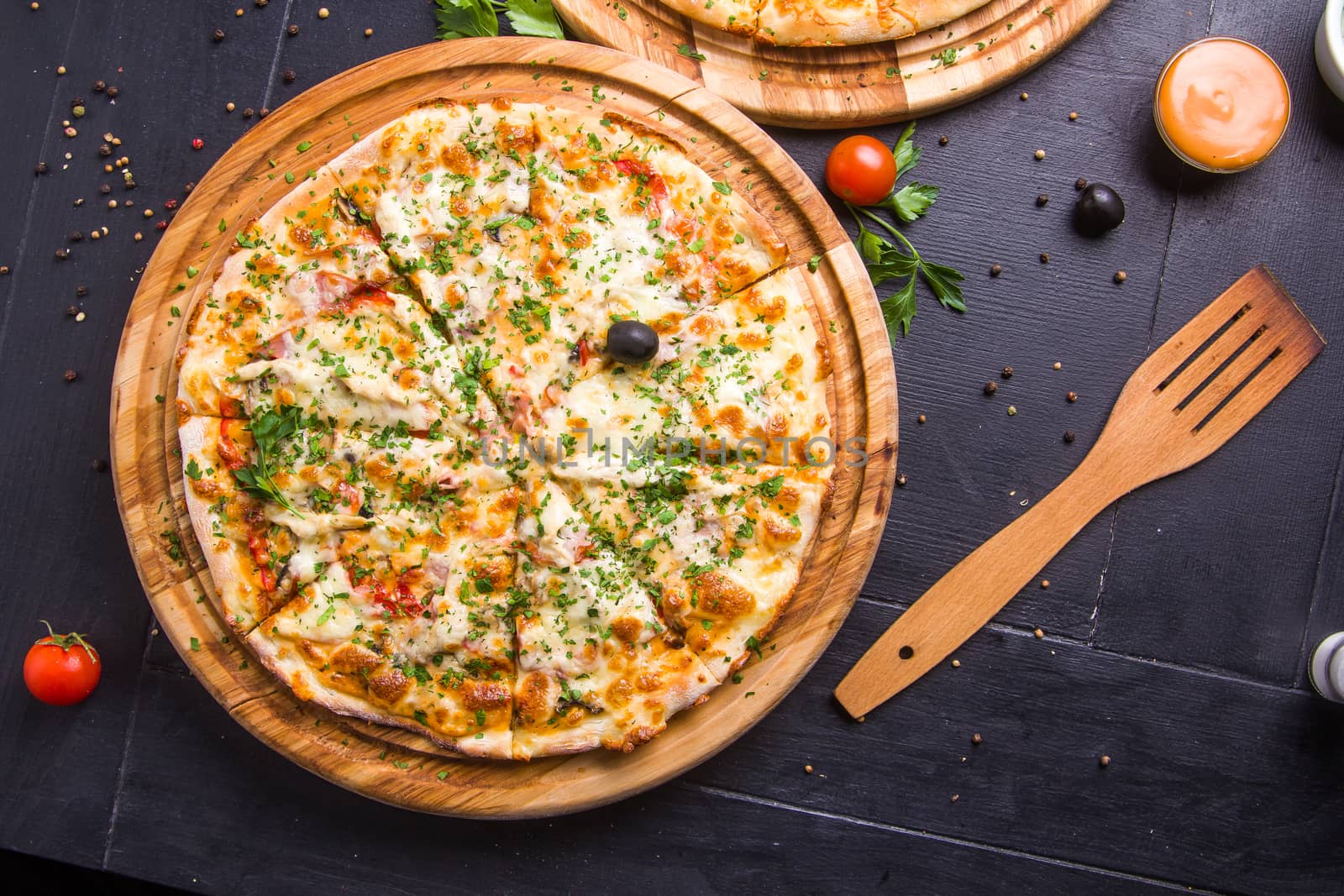 Concept: healthy food, diet. fast food. Fresh baked pizza on a wooden board with ingredients and cutlery around.