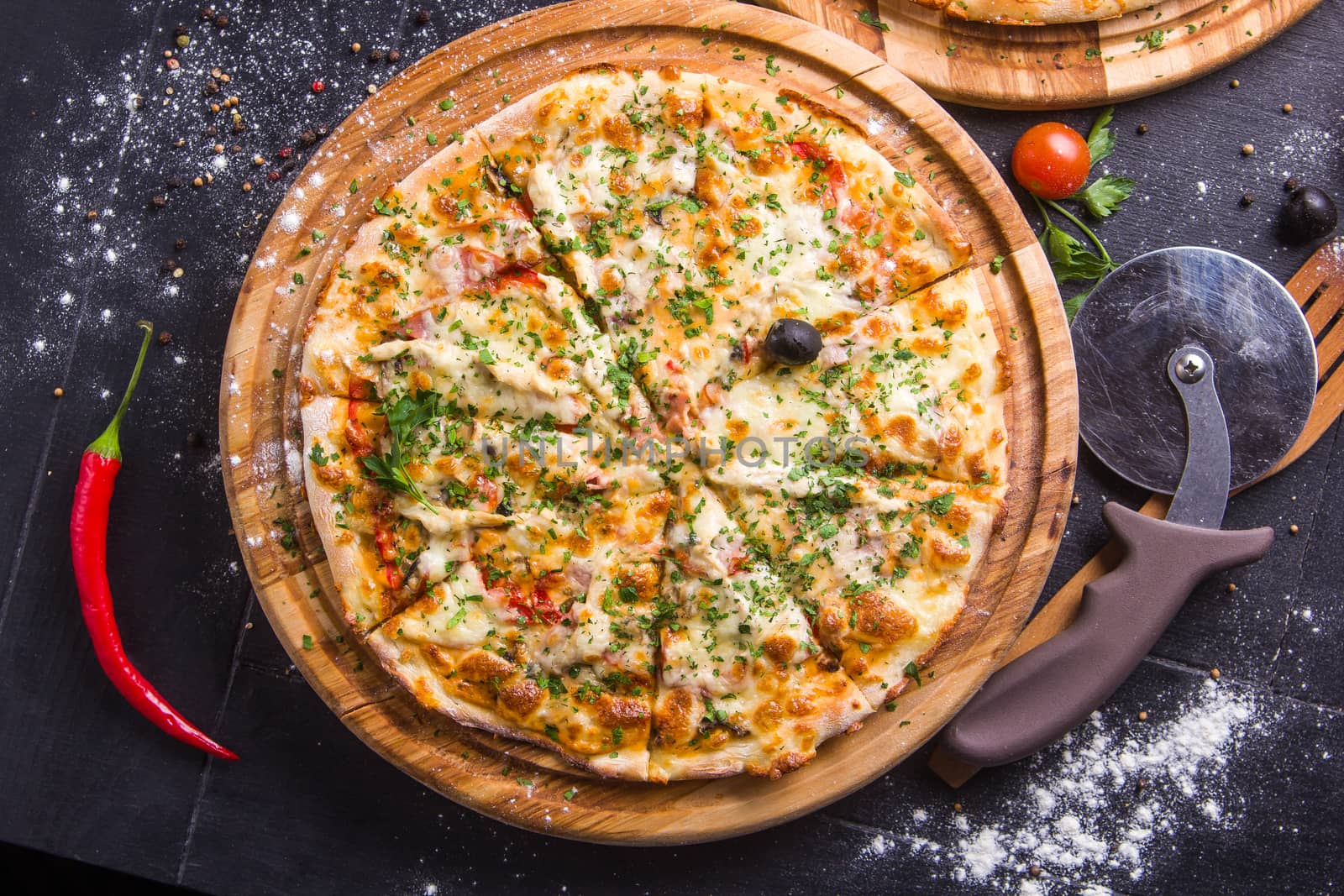 Concept: healthy food, diet. fast food. Fresh baked pizza on a wooden board with ingredients and cutlery around.