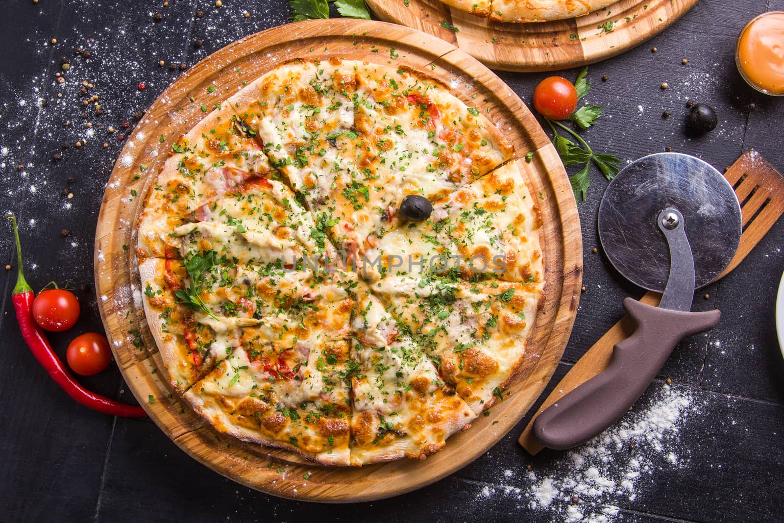 Concept: healthy food, diet. fast food. Fresh baked pizza on a wooden board with ingredients and cutlery around.