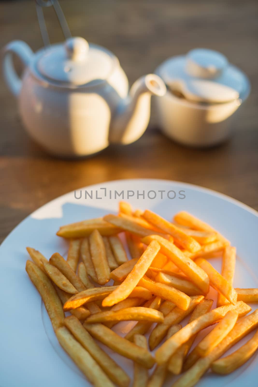 French fries with ketchup and on wooden table. Top view sunny evening by skrotov