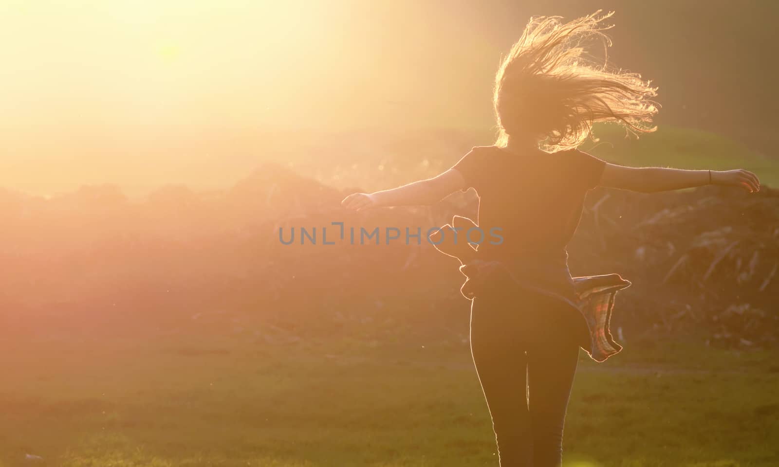 Girl  jumping up in a beautiful sunset setting