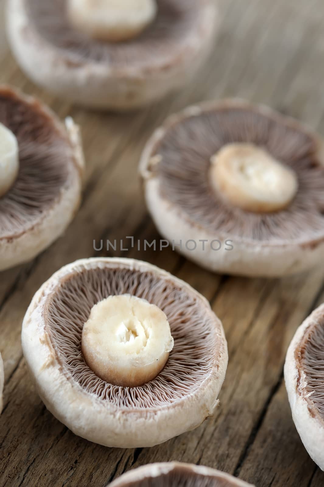 Champignon mushrooms sliced on wooden table
