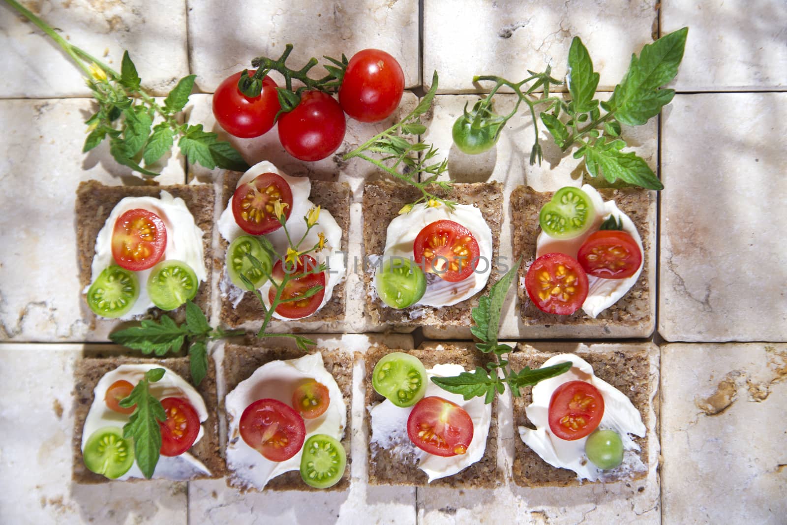 Presentation of slices of wholemeal bread with cheese and cherry tomatoes 