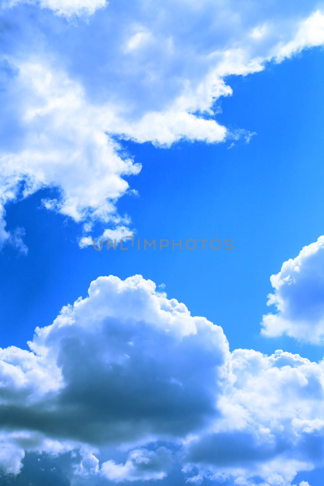 Nature background. Few big white clouds in blue sky