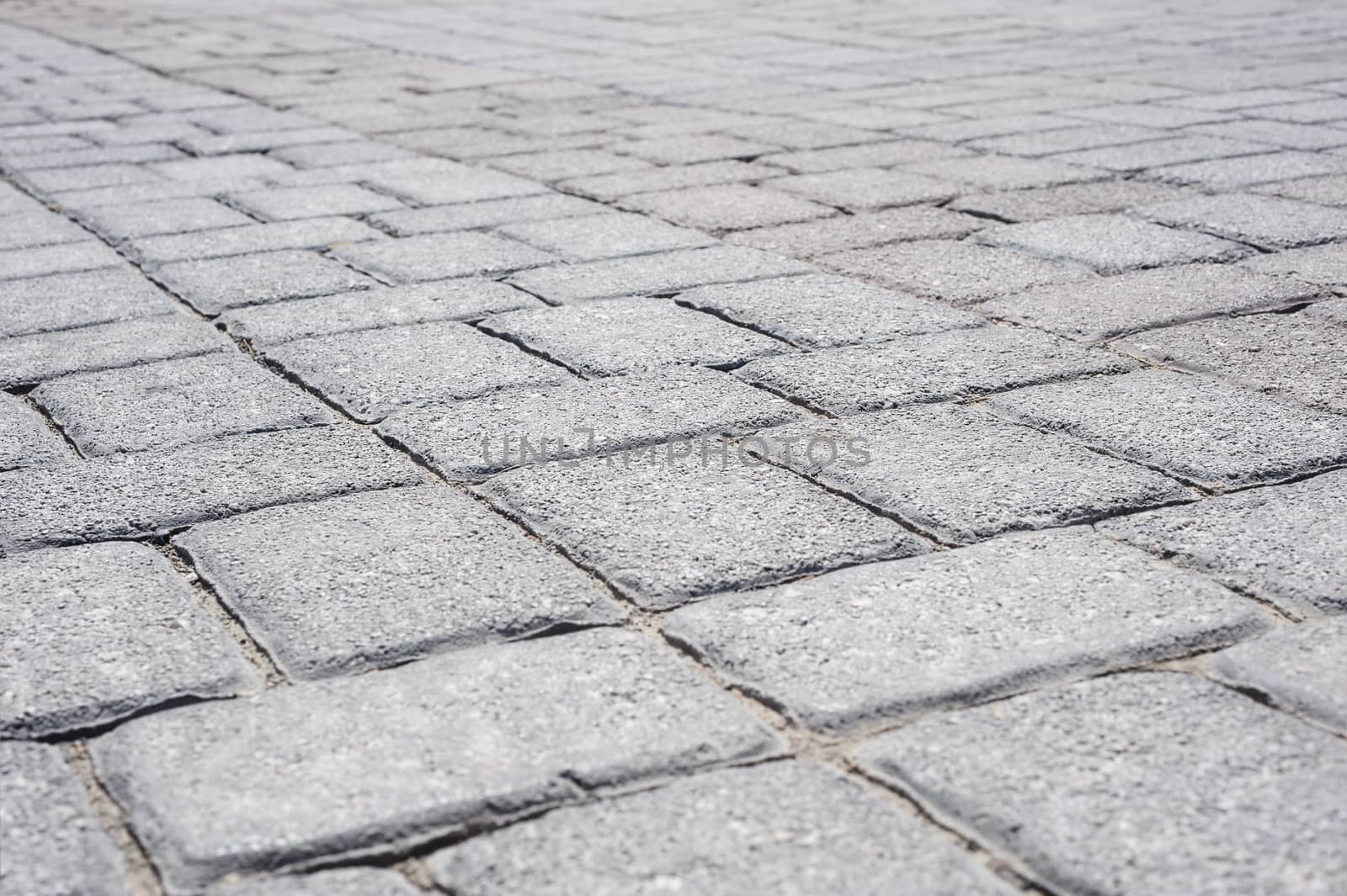 Gray brick pavement perspective background, selective focus