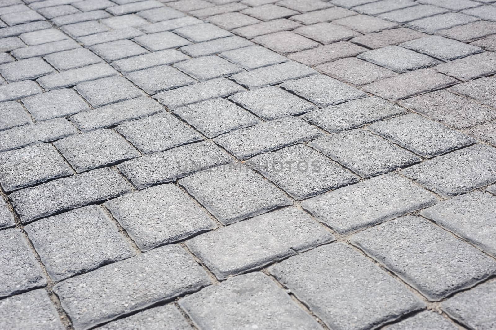 Gray brick pavement perspective background, selective focus
