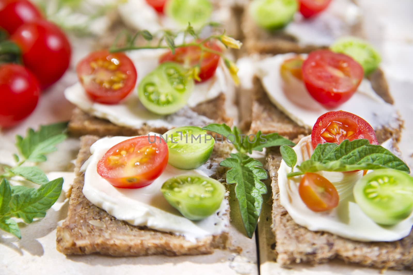 Presentation of slices of wholemeal bread with cheese and cherry tomatoes 