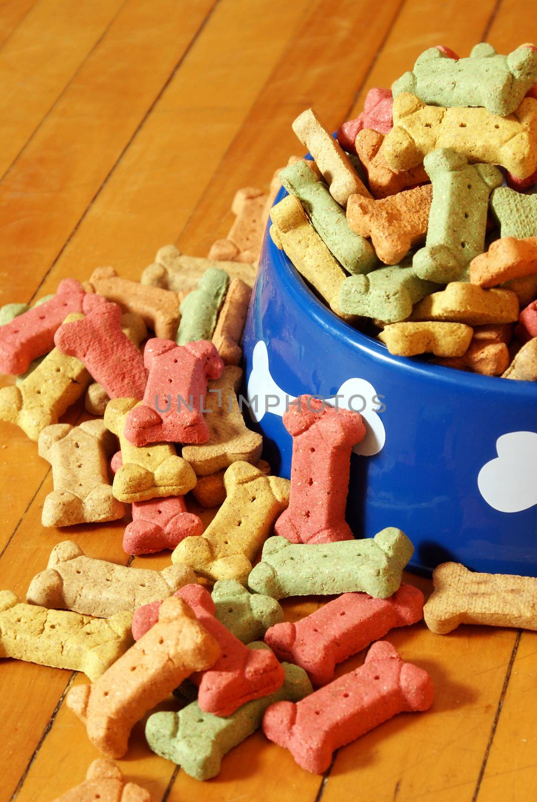 An over abundant supply of various dog treats flowing from a dish.