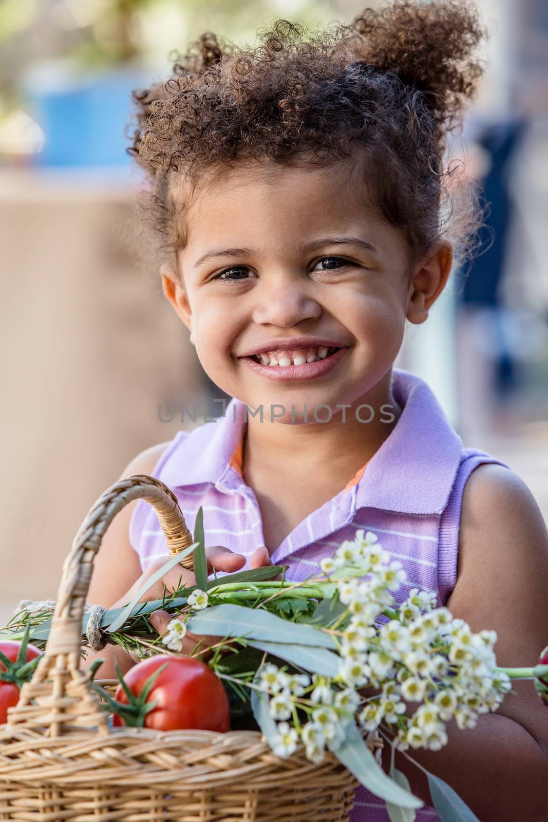 Adorable young girl with basket of produce at farmers market