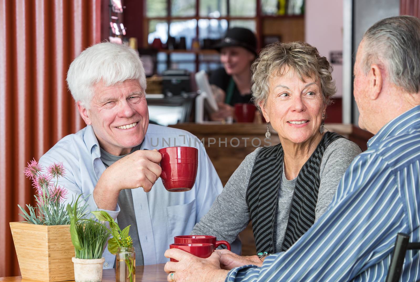 Smiling man with friends in a coffee house