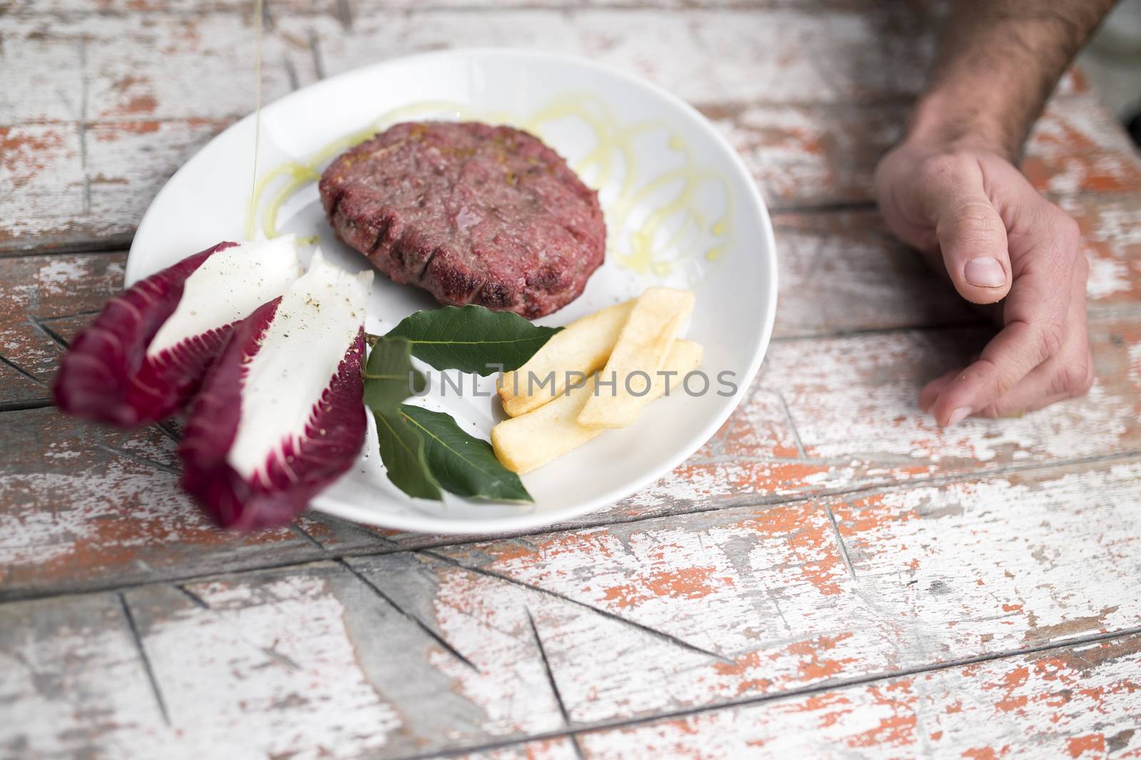 Delicious Burger on dish with salad potatoes and oil