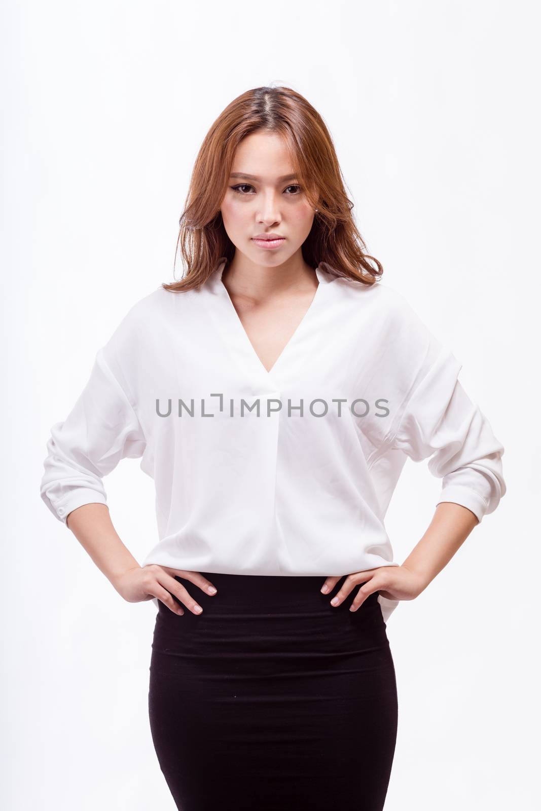 Attractive Asian American businesswoman with hands on hips looking at camera