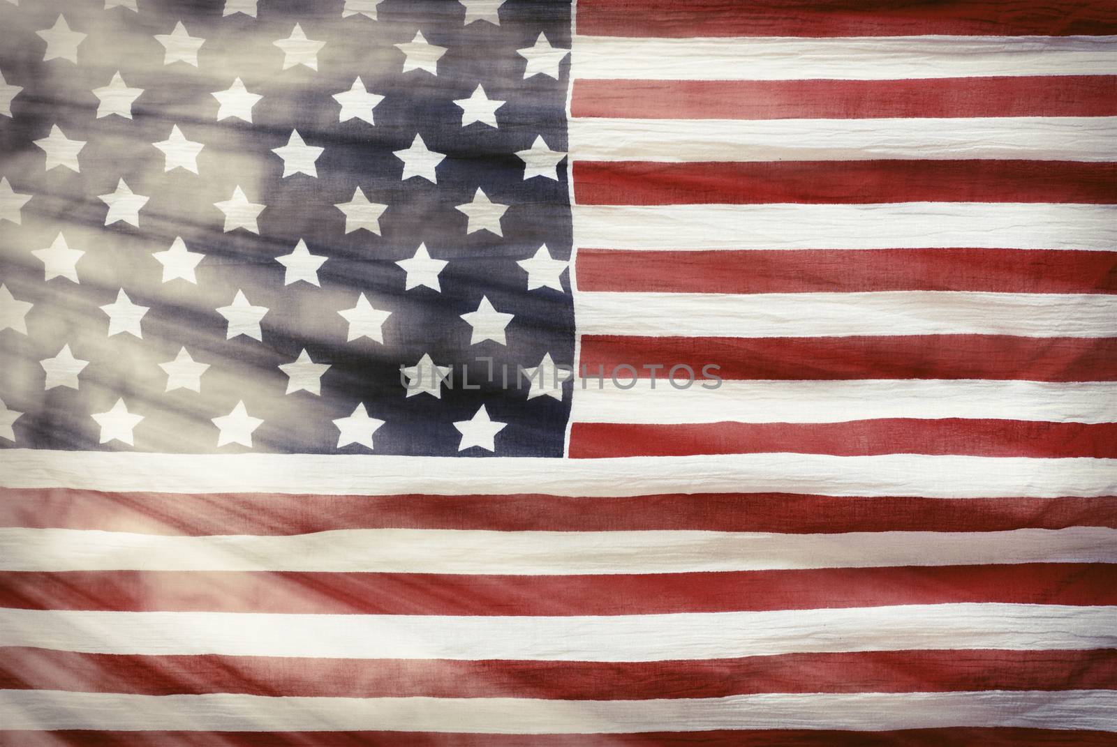 weathered American flag with sun flares background