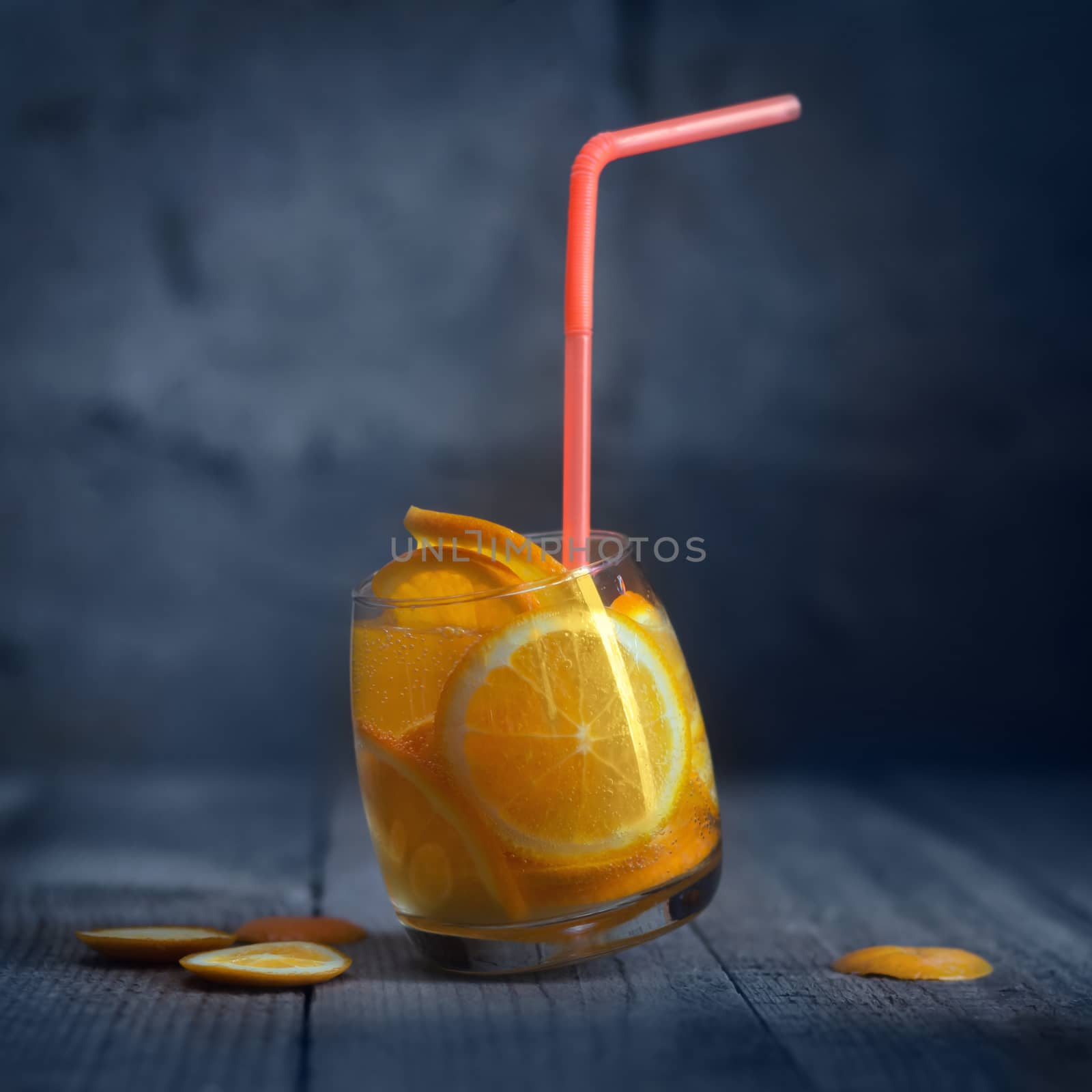 Lemonade with orange in the glass , on the old boards. Defocused background, rustic style, bokeh