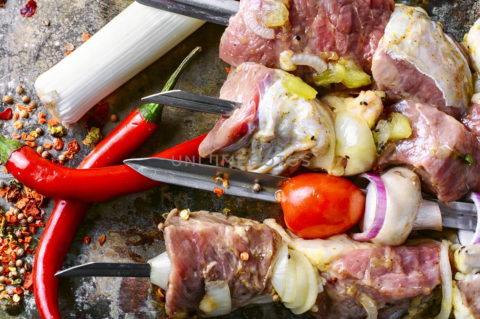 Raw pieces of beef threaded on skewers for kebabs