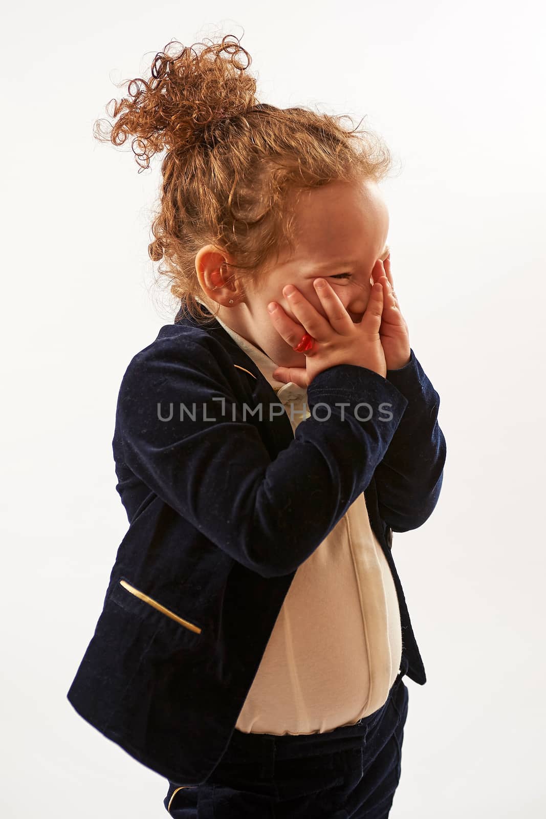 Little girl in black suit standing and pouting