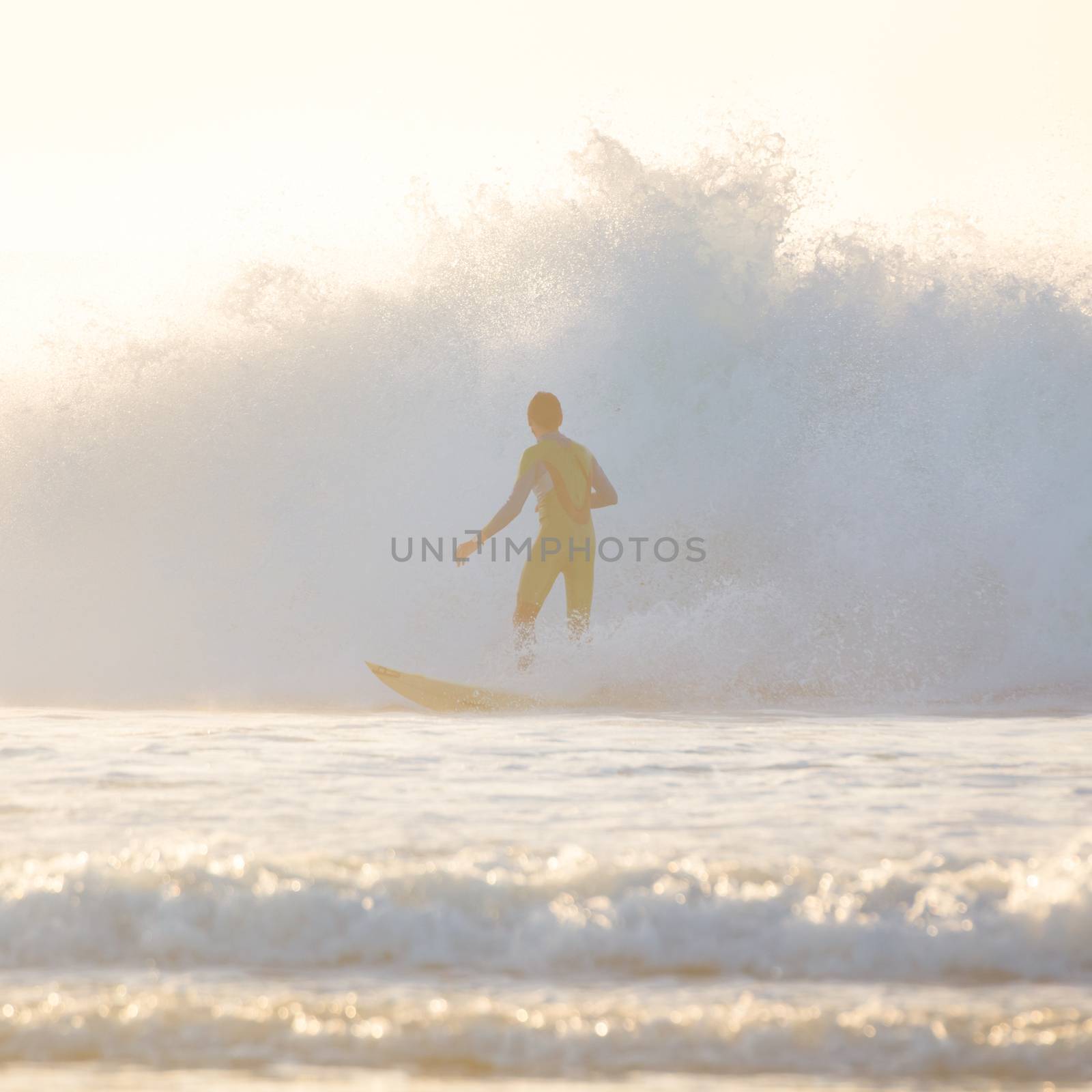 Surfer riding a powerful wave. Square composition.