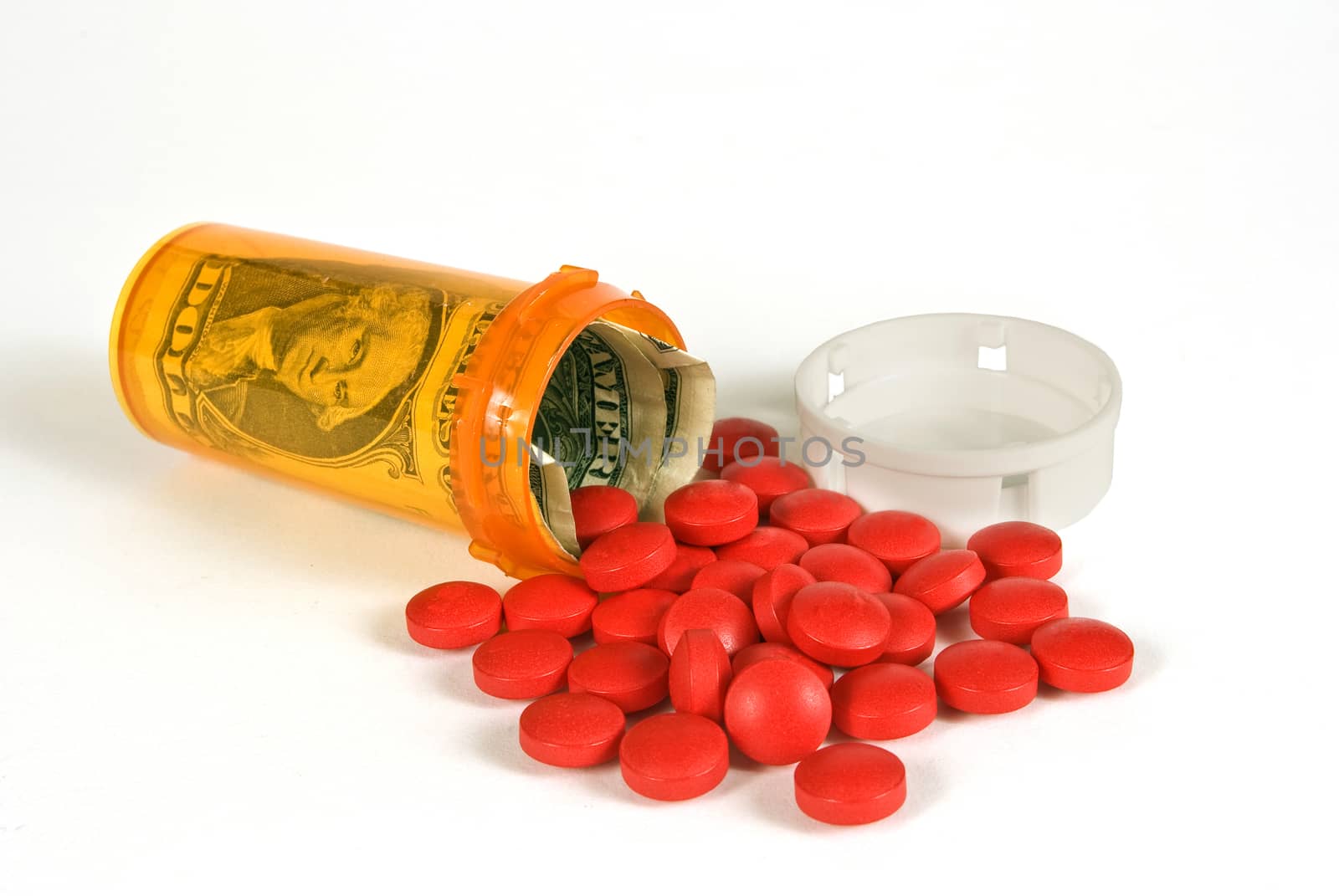 Horizontal shot of pill bottle with money inside and red pills spilling out.