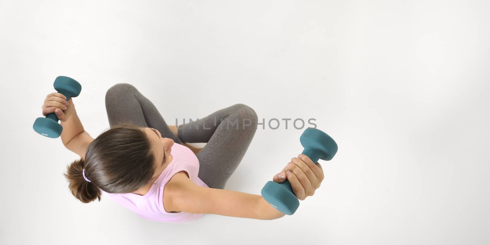 Young fit woman lifting dumbbells isolated on white background