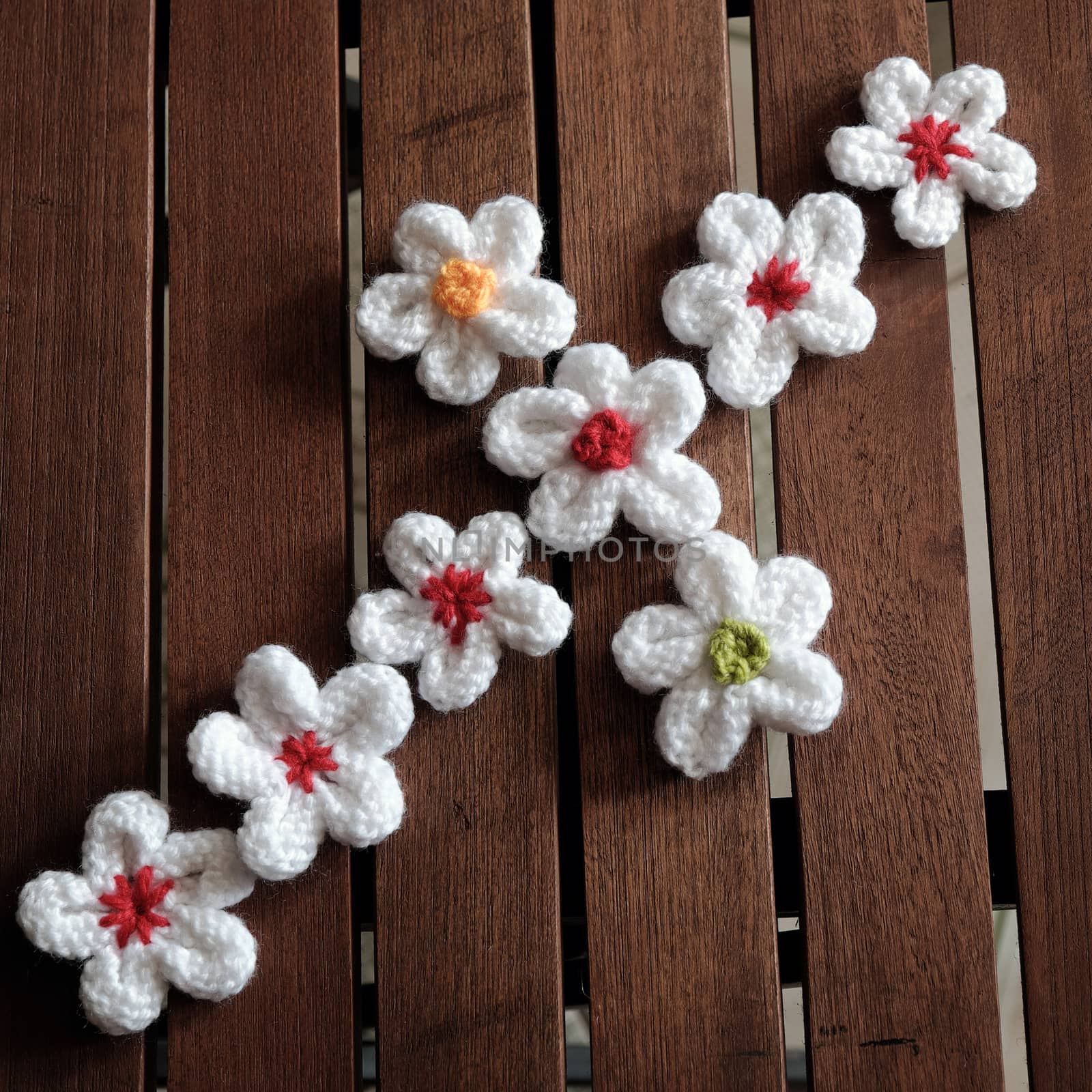 Group of handmade product for mother day, white daisy flower on wood background, make by knit from yarn