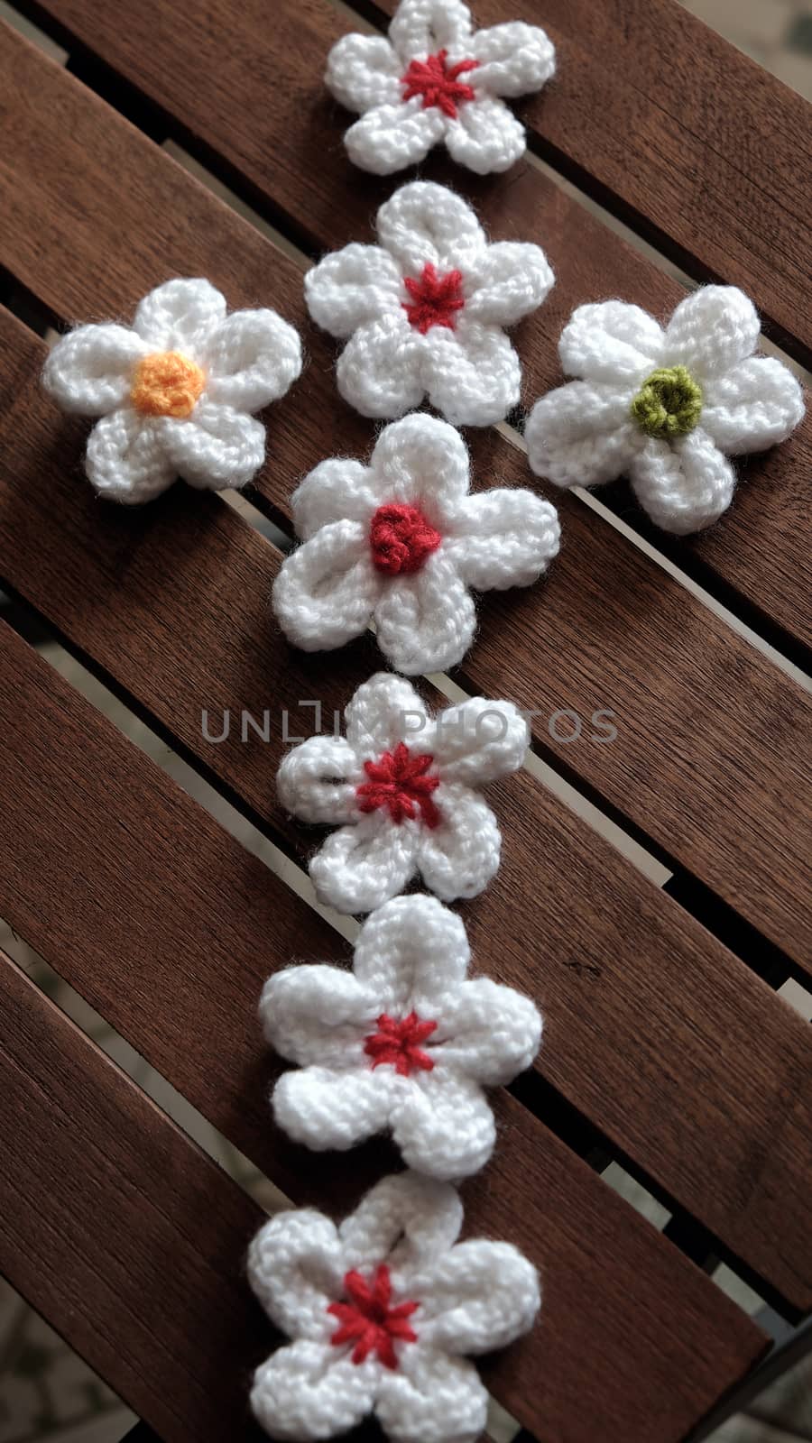 Group of handmade product for mother day, white daisy flower on wood background, make by knit from yarn