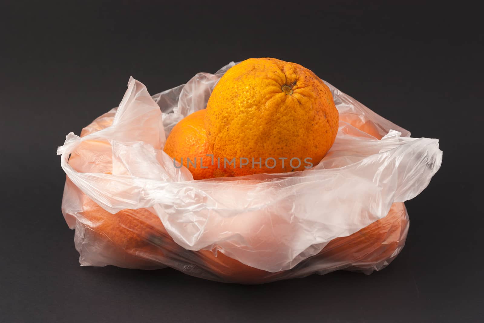 Oranges in a white envelope on a black background by mailos